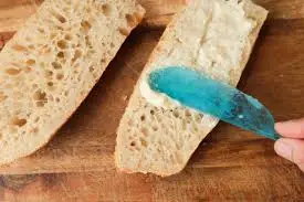 spreading garlic butter on bread