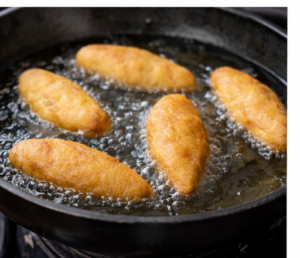 Jamaican festival dumplings frying in a pan