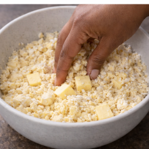 Man mixing butter into ingredients in a bowl